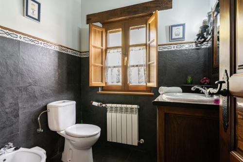 a bathroom with a toilet and a sink at Maseda 2 in Villayón