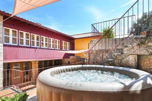 a hot tub in a yard next to a building at Quinta Rolim do Bouro By Sé Apartamentos in Roucio