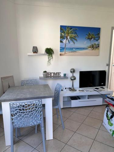 un salon avec une table et une télévision dans l'établissement Appartement dans villa roi soleil, à Antibes