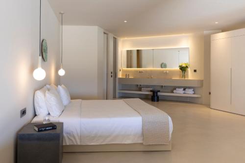 a bedroom with a white bed and a bathroom at Santopaz Suites in Oia