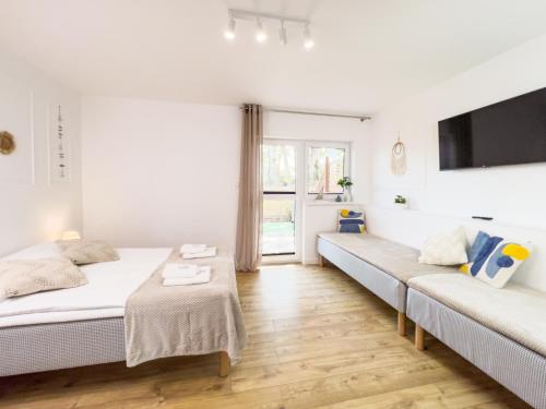 a bedroom with two beds and a couch at APARTAMENT 5B BLUE MARINE Poddąbie Basen Odkryty Brodziki Plac Zabaw in Poddąbie