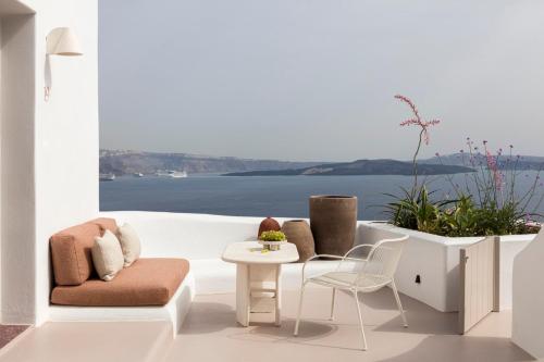 a living room with a view of the water at Canaves Ena - Small Luxury Hotels of the World in Oia