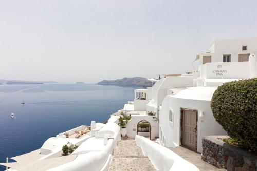 a row of white buildings with a view of the ocean at Canaves Ena - Small Luxury Hotels of the World in Oia