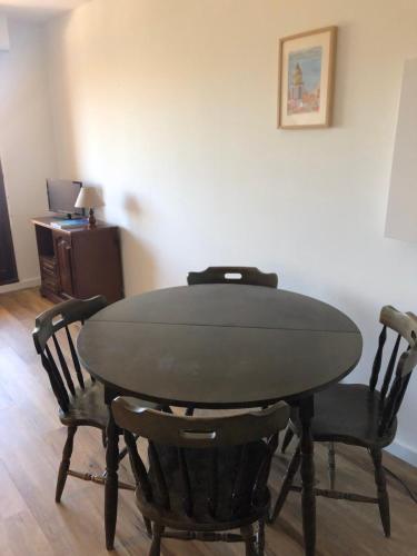 une table à manger avec quatre chaises et un bureau dans l'établissement Comfortable 40 m apartment with sea view, à Sainte-Maxime