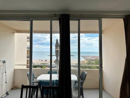 une salle à manger avec une table et une vue sur l'océan dans l'établissement Duplex Valras face mer, à Valras-Plage
