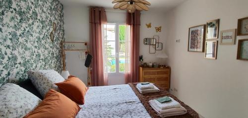 a bedroom with a bed with two towels on it at Maison d'Hestia, charme, piscine, proche du bord de mer et de Royan in Arces-sur-Gironde