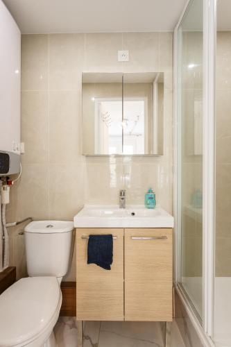 a bathroom with a toilet and a sink and a shower at Blanc Mesnil Nid d'amour in Le Blanc-Mesnil