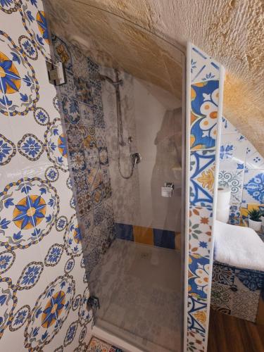 a bathroom with a shower with blue and white tiles at Casa vacanze San Martino in Ginosa