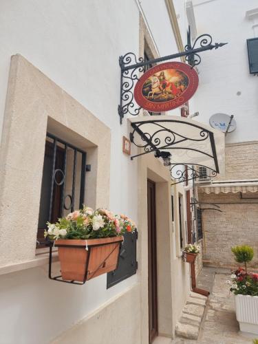 a sign on the side of a building with a flower pot at Casa vacanze San Martino in Ginosa