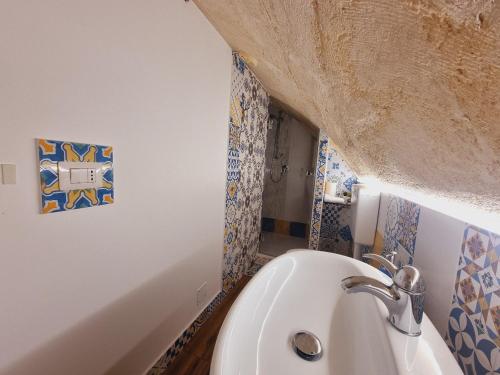 a white sink in a bathroom with blue and white tiles at Casa vacanze San Martino in Ginosa