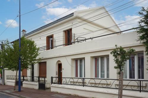 a white house with a fence in front of it at LEON GAMBETTA F2 TERRASSE JARDIN in Drancy