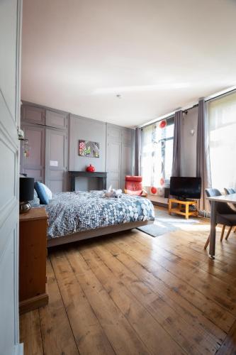une chambre avec un lit et un parquet dans l'établissement Maison du jardin botanique 7 min centre et Gare, à Tourcoing