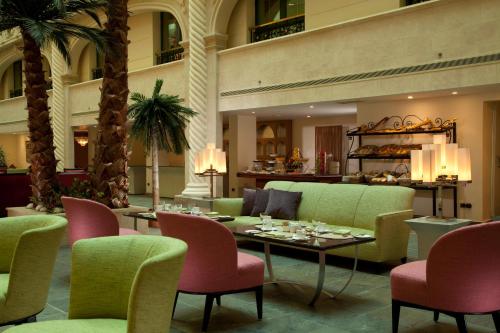 a lobby with a table and chairs and palm trees at Sonesta Hotel Tower & Casino Cairo in Cairo