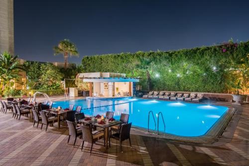 an outdoor dining area with a pool at night at Sonesta Hotel Tower & Casino Cairo in Cairo