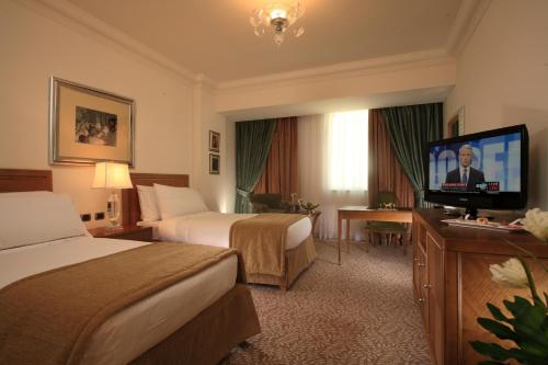 a hotel room with two beds and a flat screen tv at Sonesta Hotel Tower & Casino Cairo in Cairo