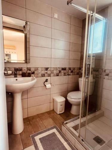 a bathroom with a toilet and a sink and a shower at Maistrali Hotel & Restaurant in Kalavárda
