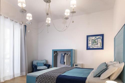 een slaapkamer met een bed en een kroonluchter bij Mya Home Luxury Apartments in Castellammare di Stabia