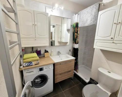 une petite salle de bains avec un lave-linge et un lavabo dans l'établissement Studio cosy design au coeur de la ville, à La Grande Motte