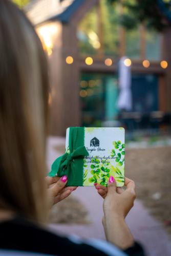 a woman holding a green and white box with a bow at Dziupla House in Czarna
