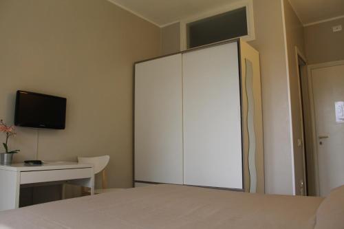 a bedroom with a large white closet and a desk at Ute Hotel in Lido di Jesolo