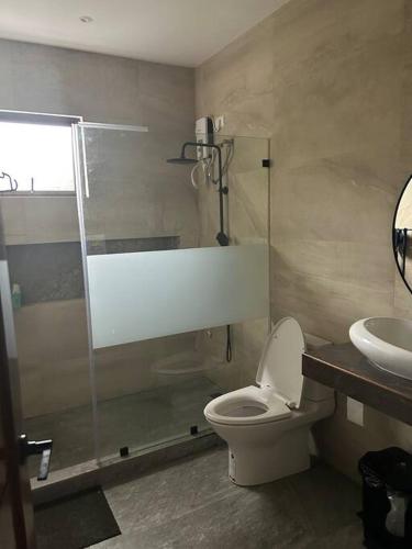 a bathroom with a shower and a toilet and a sink at 3 Storey Beachfront Villa with Pool by JCV in Nasugbu