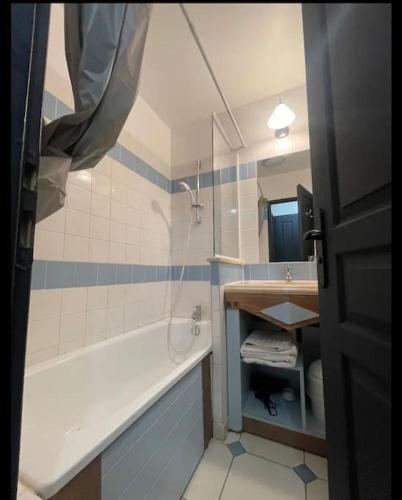 une salle de bain avec une baignoire, un lavabo et un miroir dans l'établissement Résidence du Golf, à Deauville