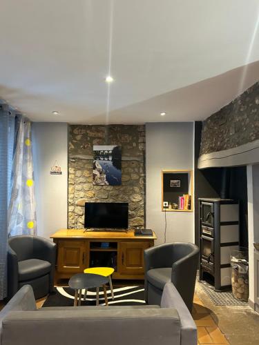 un salon avec un canapé et une télévision dans l'établissement Maison de Village Chez Popeye, à Vogüé