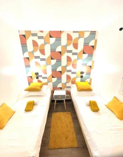 Cette chambre comprend 2 lits avec des oreillers jaunes. dans l'établissement Résidence du Golf, à Deauville