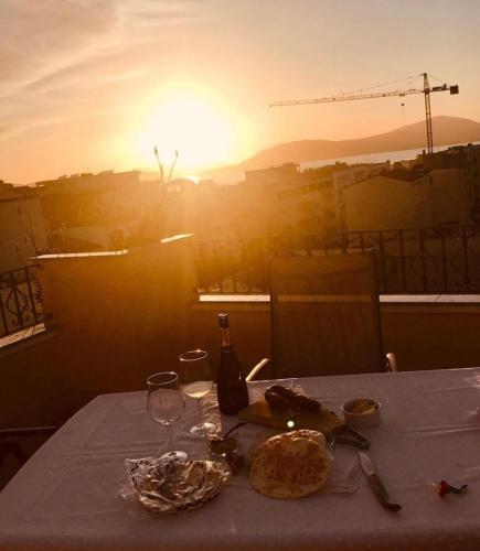 a table with food and wine glasses and the sunset at B&B Su Canistreddu in Alghero