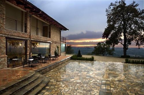 a house with a patio with tables and chairs at Archisa Relais Hostaria in Farigliano