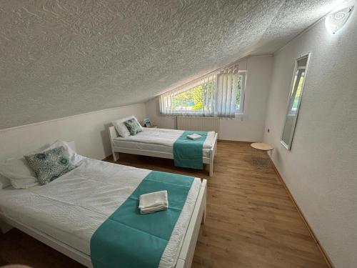 a bedroom with two beds and a window at Riverside Resort Una in Bihać