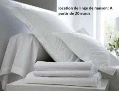 une pile de serviettes blanches sur une table avec une fenêtre dans l'établissement Studio cosy design au coeur de la ville, à La Grande Motte