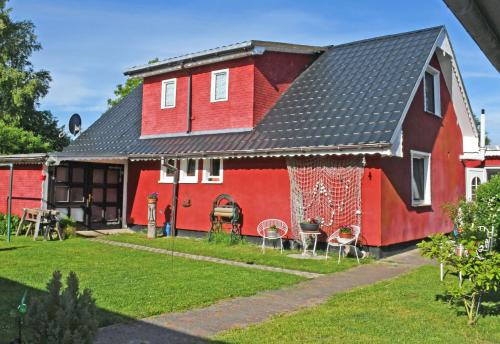 a red house with a black roof at Pension im Seebad Breege in Drewoldke