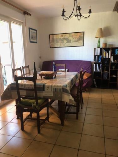 - une table à manger et des chaises dans le salon dans l'établissement l'Oustalot, à Lanton