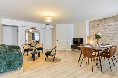 un salon avec un canapé, une table et des chaises dans l'établissement Résidence Montparnasse by Studio prestige, à Paris
