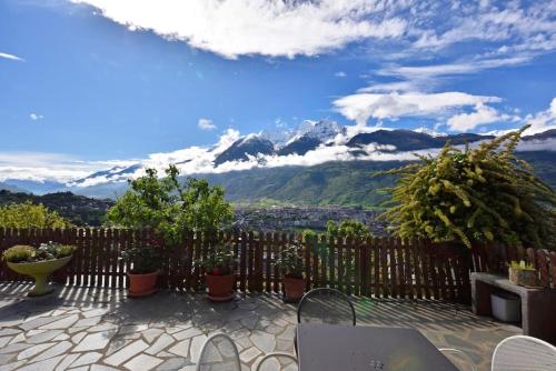 a patio with a fence and mountains in the background at Zona Panoramica - Bluchalet in Aosta