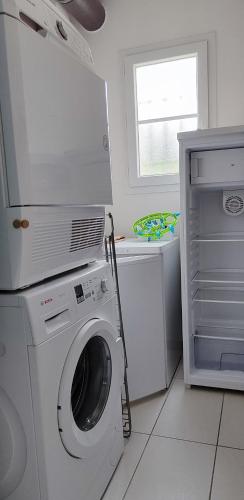 a white washing machine in a kitchen with a window at Maison d'Hestia, charme, piscine, proche du bord de mer et de Royan in Arces-sur-Gironde