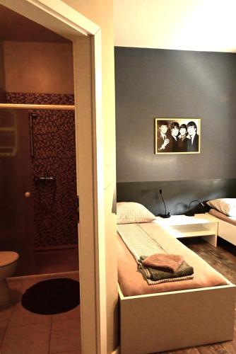 a bedroom with a bed and a bathroom with a shower at Rock Rooms Pula in Pula