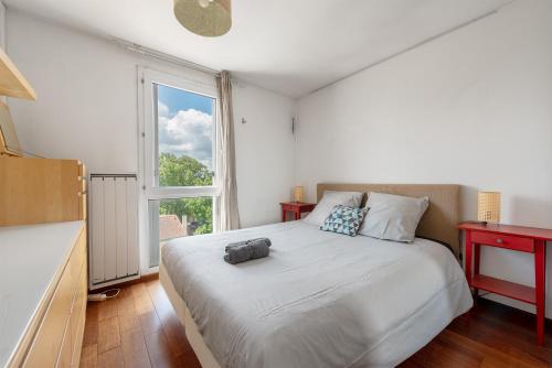 une chambre avec un grand lit et une fenêtre dans l'établissement Le République T3 hyper-centre - parking - terrasse, à Toulouse