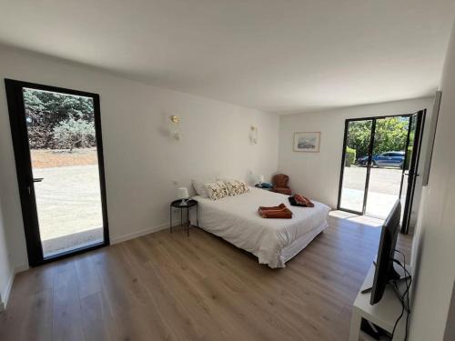 une chambre blanche avec un lit et une télévision dans l'établissement Havre de paix sur Roussillon, à Roussillon