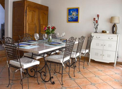 - une salle à manger avec une table, des chaises et des verres à vin dans l'établissement Quartier Arago - Maison 3 chambres plage à pied, à Les Sables-dʼOlonne