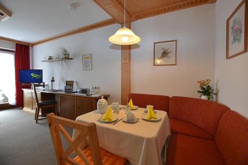 a dining room with a table and a couch at Gästehaus Bergfrieden, Ferienwohnung Eva in Bayersoien
