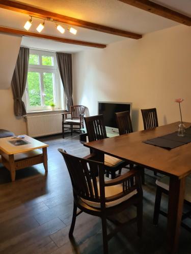 a living room with a wooden table and chairs at Ferienwohnung RUHRPERLE für 1 bis max 9 Erwachsene in Marl
