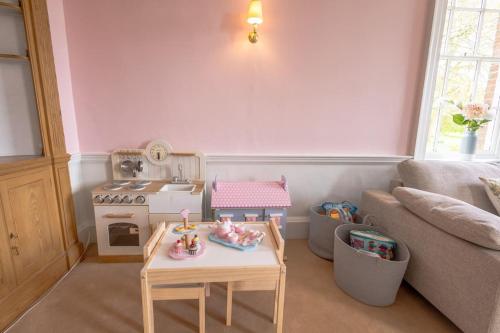 a living room with a toy stove and a table at The Old Rectory in Hatfield