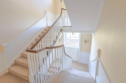 a staircase with white railings in a home at The Old Rectory in Hatfield