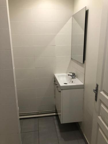 une salle de bain blanche avec un lavabo et un miroir dans l'établissement Beautiful studio next to metro, à Paris