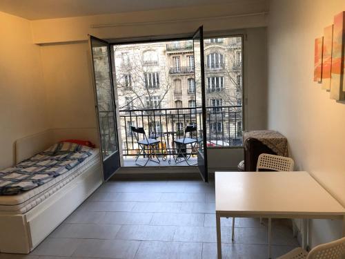 Cette chambre comprend un lit et offre une vue sur un bâtiment. dans l'établissement Beautiful studio next to metro, à Paris