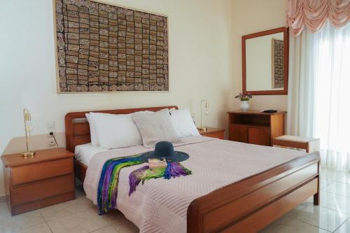 a bedroom with a bed with a hat on it at Kostoula's House Beachfront by 8essentially in Stalos