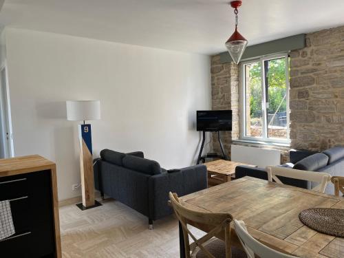 un salon avec une table et un canapé dans l'établissement Maison bretonne typique plage des oiseaux à Fouesnant Beg Meil, à Fouesnant