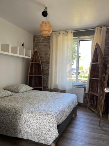 une chambre avec un lit et une fenêtre dans l'établissement Maison bretonne typique plage des oiseaux à Fouesnant Beg Meil, à Fouesnant